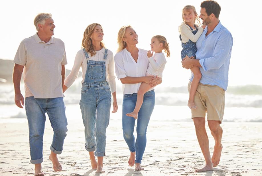 Familie mit 3 Generationen spaziert am Strand